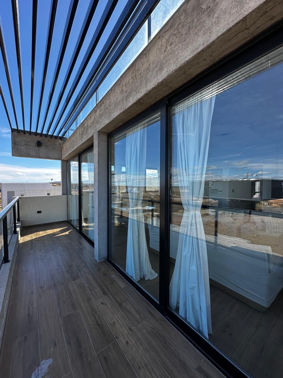 Galería con pérgola y cerramiento vidriado de piso a techo, fotografía de obra