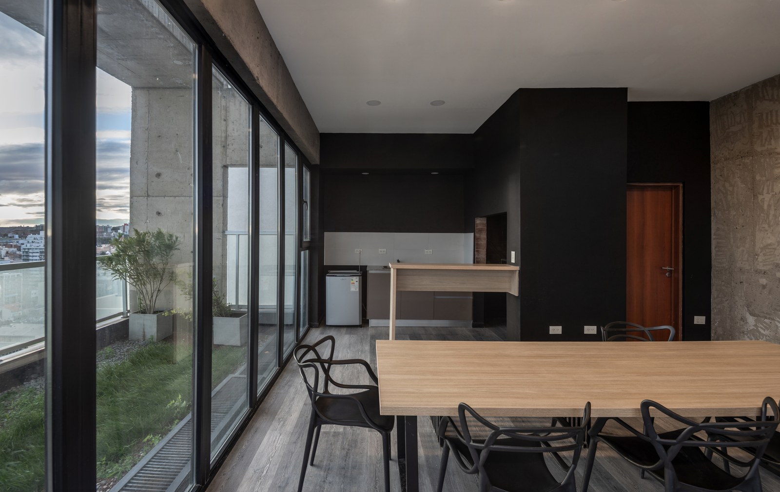Salón con mesa larga y cocina, abierto a la terraza, fotografía de obra