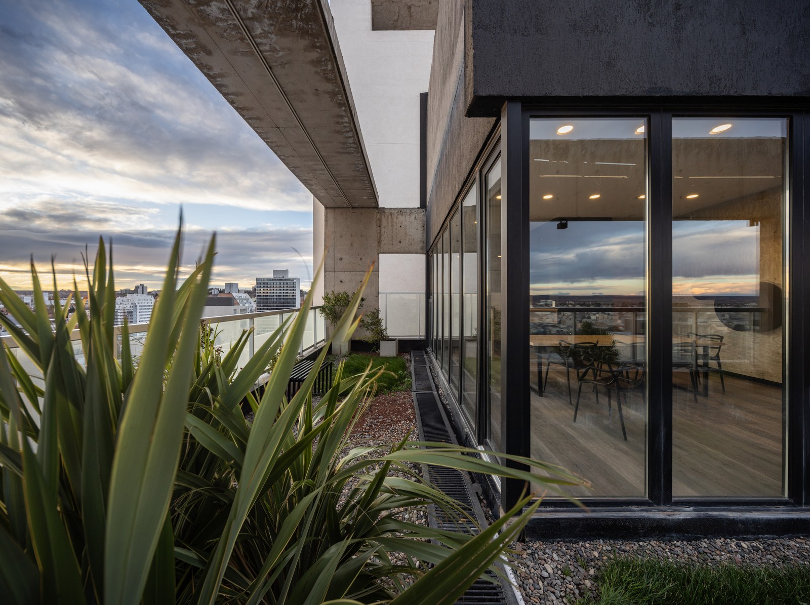 Terraza con canteros y el salón detrás del vidrio, fotografía de obra